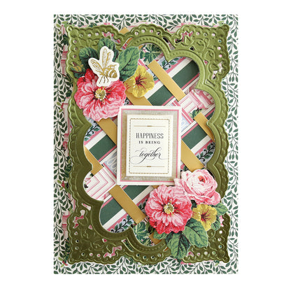 A green and pink card adorned with flowers, Annalise 12x12 Cardstock and Embellishments, and patterned papers.