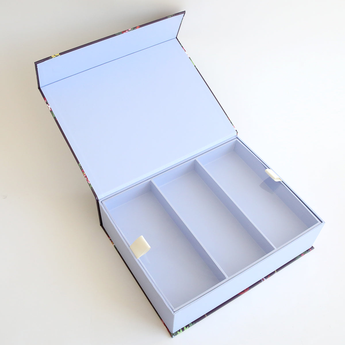 An Embellishment Storage Box - Astrid with three compartments is open on a white surface.
