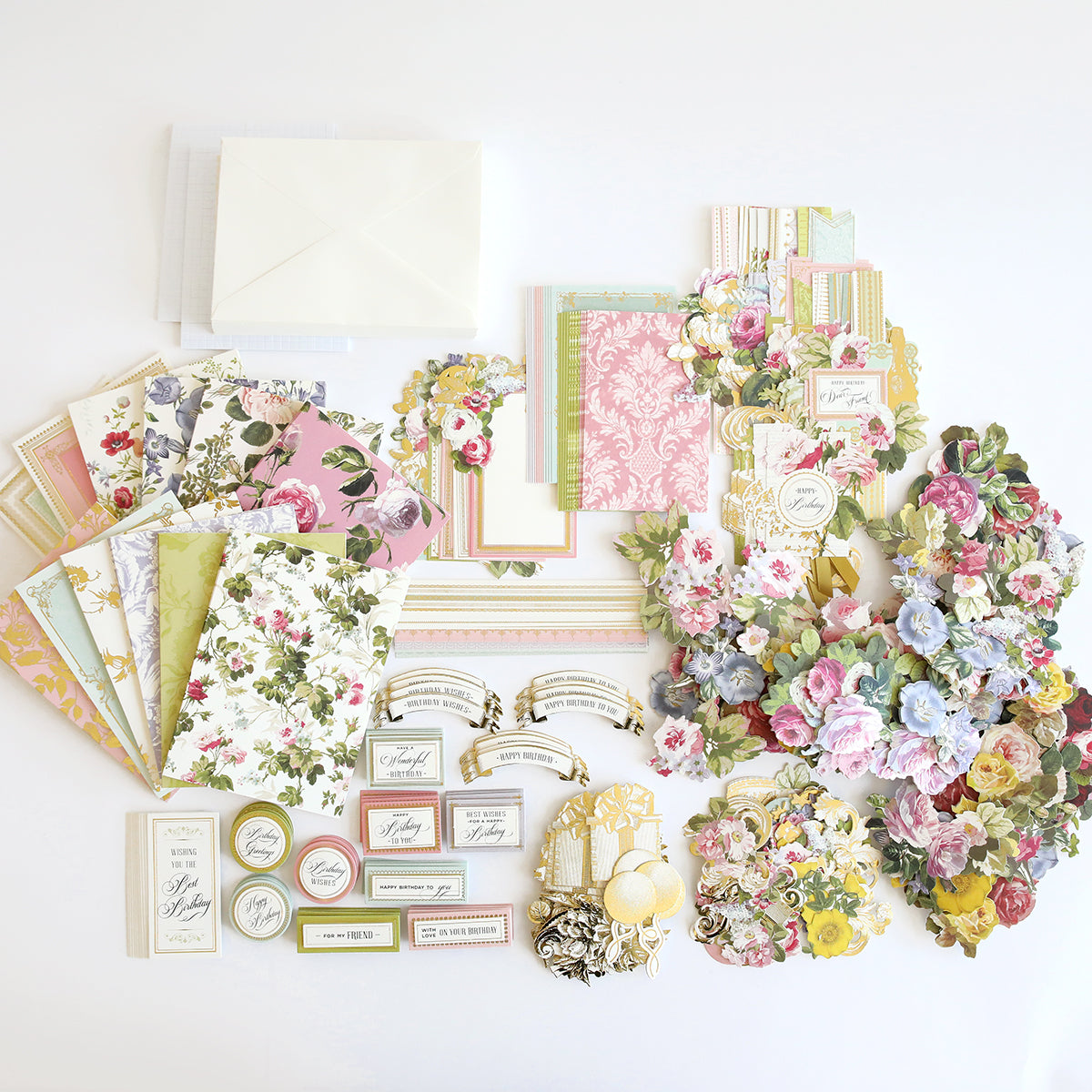 A delightful Birthday Greetings Card Making Kit featuring a collection of assorted floral-themed stationery, including envelopes, patterned papers, cards, tags, and embellishments laid out on a white surface. Perfect for crafting handmade card kits or sending Birthday Greetings cards.