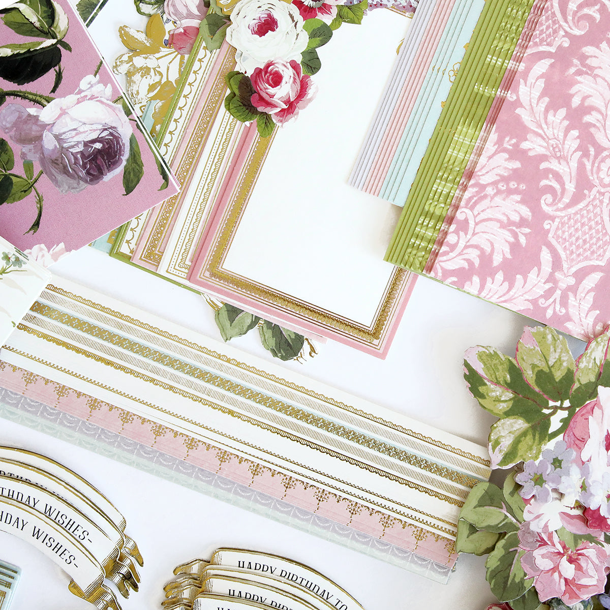 A collection of decorative floral-themed stationery, including envelopes, cards, and floral embellishments perfect for a Birthday Greetings Card Making Kit, all beautifully arranged on a white surface.