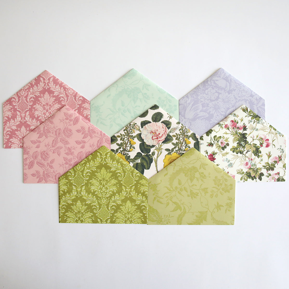 A collection of Birthday Greetings Envelope Liners in various pastel colors and floral patterns, arranged in a fan shape on a white background, each featuring delicate foil accents.