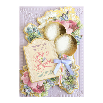 An ornate birthday card with floral motifs, "wishing you the best & brightest birthday" text using Birthday Sentiment Rub Ons, and two gold balloons with a blue bow.