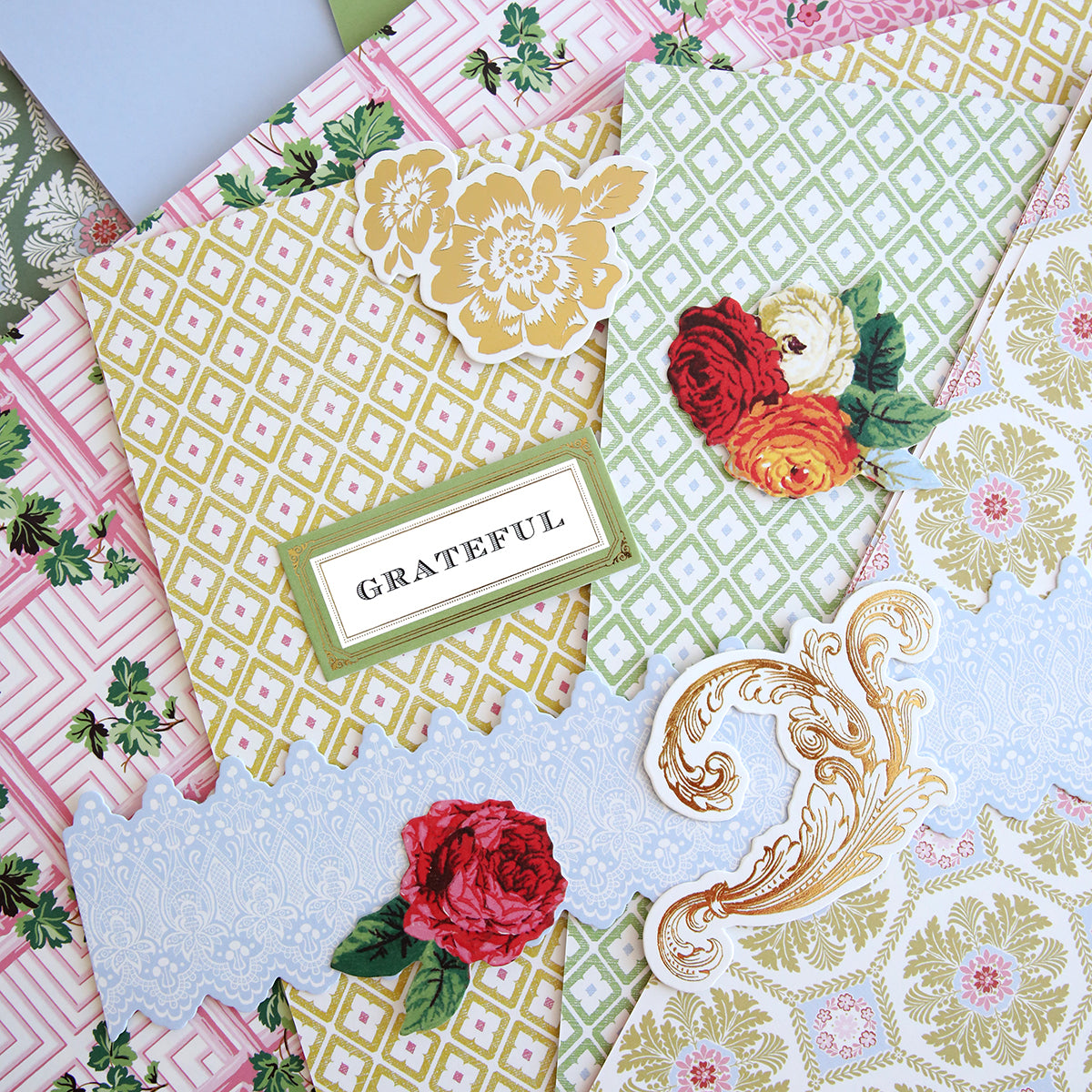 A pile of papers adorned with Annalise 12x12 Cardstock and Embellishments, including roses and flowers.