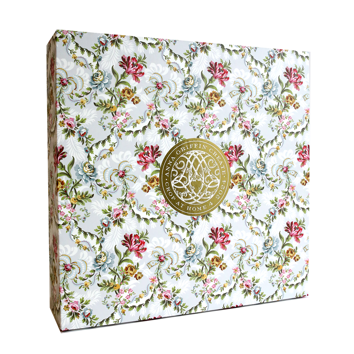 The Crop at Home 4 Scrapbook Collection includes a decorative box crafted from premium cardstock, adorned with a floral pattern and highlighted by a gold circular emblem at the center.