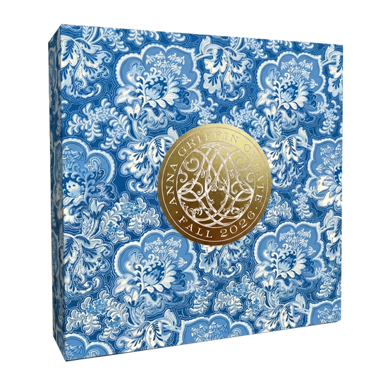 A blue floral-patterned box with a large gold seal reading "Anna Griffin | Create Fall 2026," perfect for craft classes and connecting with the creative community.