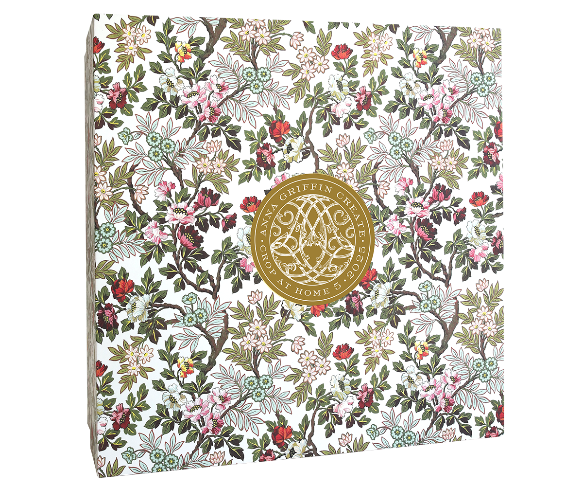 The Crop at Home 5 Ultimate Materials Kit is a square scrapbook made from high-quality cardstock, featuring a red, pink, green, and white floral cover with a central gold circular emblem.