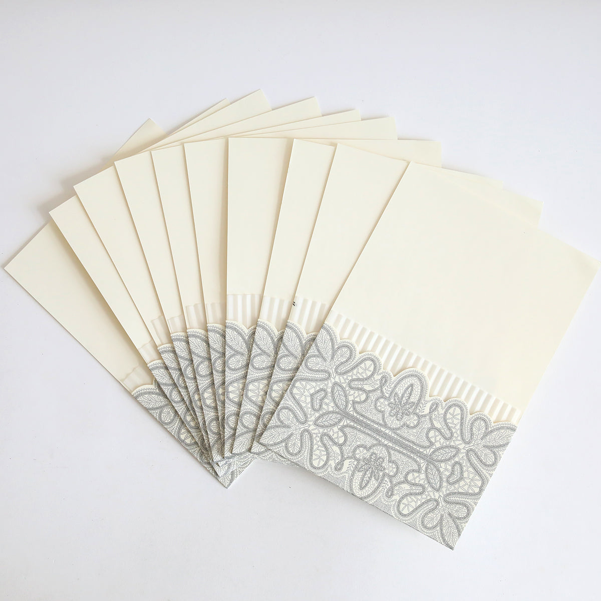 A pack of ten Silver Glitter Pleated Pocket envelopes, featuring cream color with silver patterns and pleated trim—ideal for elegant wedding invitations.