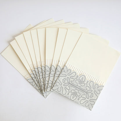 A pack of ten Silver Glitter Pleated Pocket envelopes, featuring cream color with silver patterns and pleated trim—ideal for elegant wedding invitations.