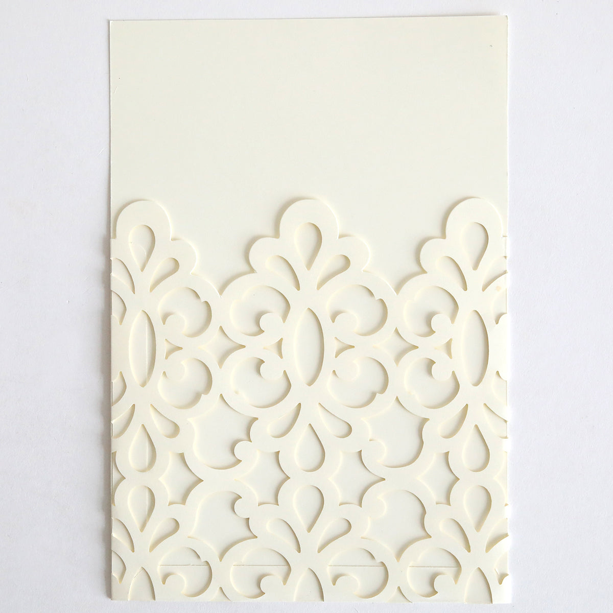 The Ivory Medallion Diecut Pocket 10 pack features ivory cards with ornate, symmetrical laser-cut patterns on the lower half, resembling elegant invitation pockets, displayed against a plain white background.