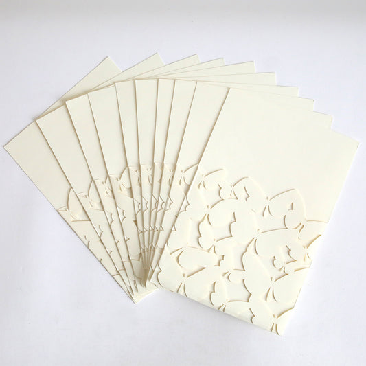 A pack of ten Ivory Butterfly Diecut Pocket cards features cream-colored, embossed floral cut-out designs and elegant ivory butterfly pockets, displayed fanned out on a flat white surface.