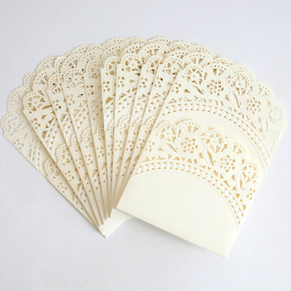 The Ivory Double Scallop Lace Pocket 10 pack features intricately designed ivory laser-cut envelopes with floral patterns and elegant double scallop edges, ideal for wedding invitations, shown fanned out on a white background.