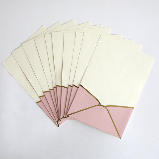 A 10-pack of Pink Metallic Envelope Pockets displayed in a fan shape on a white surface, perfect for cream-colored wedding invitations.