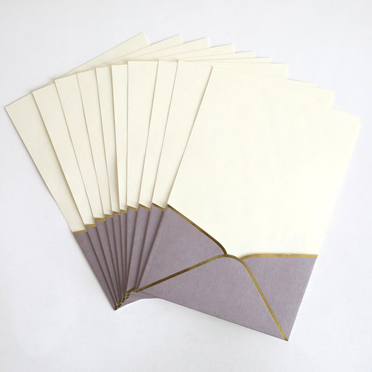 A 10-pack of Lavender Metallic Envelope Pockets with gold trim, each holding cream wedding invitations, displayed fanned out on a white background.