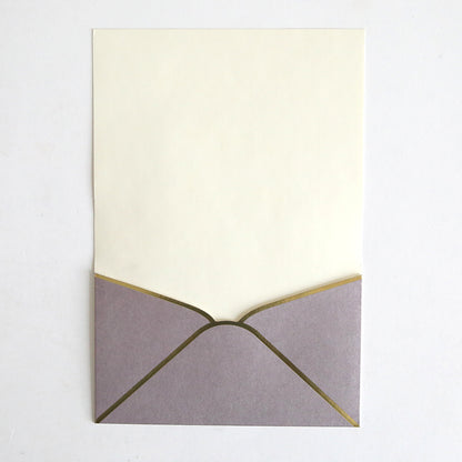 A Lavender Metallic Envelope Pocket from this 10 pack sits open on a plain white surface, revealing a blank cream-colored card inside—ideal for elegant wedding invitations.