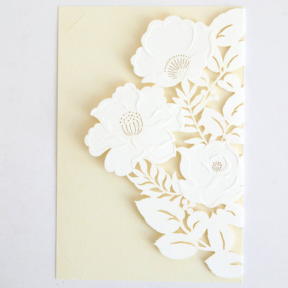 The Floral Diecut Invitation 10 pack features cream cards with three white, intricately cut-out flowers and leaves on the front, offering a delicate floral design—ideal for pairing with embossed floral invitation wraps.
