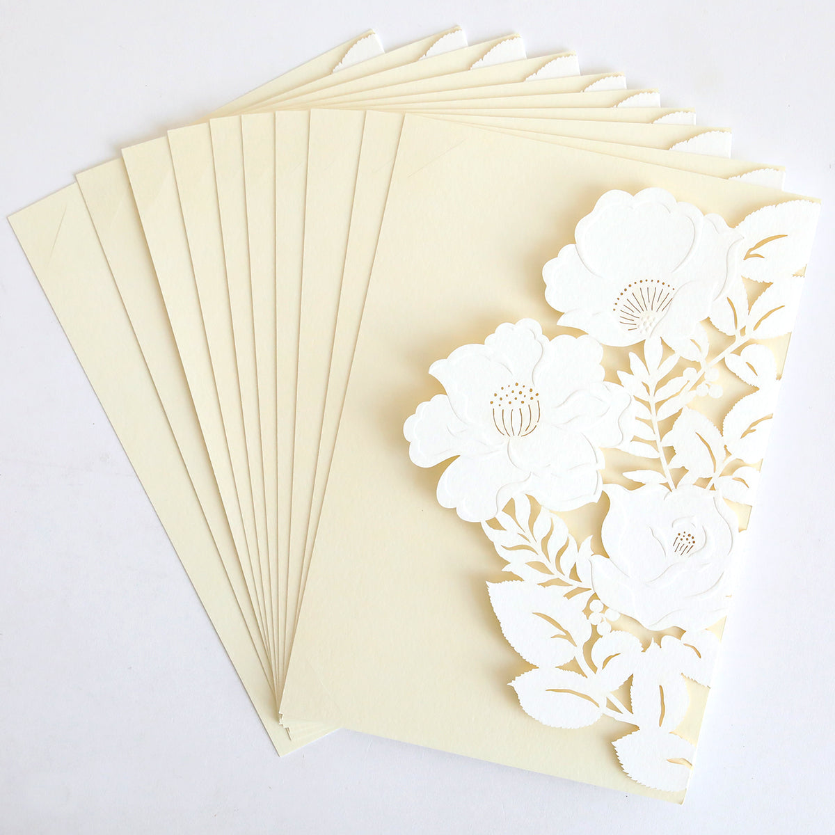 The Floral Diecut Invitation 10 pack includes cream envelopes and matching cards with an ornate white embossed floral cut-out wrap design.