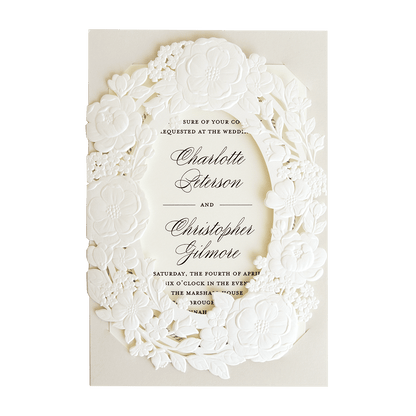 A white wedding invitation with a floral design.