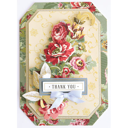 The Simply Gratitude Card Making Kit features a decorative thank you card adorned with red and gold flowers, green leaves, gold accents, and a blue ribbon, all framed by a floral patterned border—an ideal choice for handmade card enthusiasts or anyone seeking to enhance their gratitude card collection.
