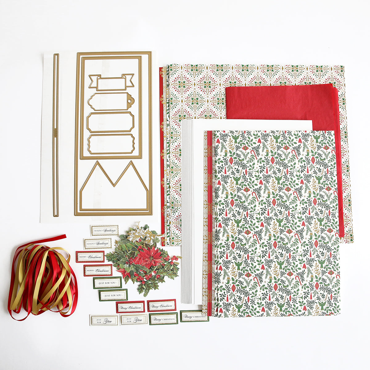 A collection of Anna Griffin Christmas Crackers Class Materials and Dies, ribbons, and small gifts on a white surface.