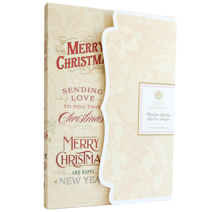 The Christmas Greetings Rub On Transfers feature gold and red "Merry Christmas" and "Happy New Year" text, with festive accents and a decorative folded insert adorned with holiday embellishments.