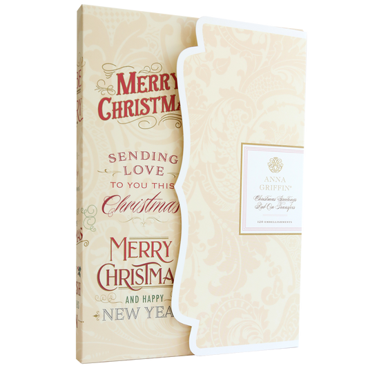 The Christmas Greetings Rub On Transfers feature gold and red "Merry Christmas" and "Happy New Year" text, with festive accents and a decorative folded insert adorned with holiday embellishments.