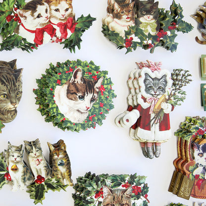 An assortment of vintage-style Victorian cat illustrations adorned with holly and mistletoe, displayed on a flat white surface. Perfect for adding paw-some sentiments to pet lovers Christmas cards or embellishing your Christmas Kitties Stickers.