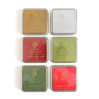 Six Christmas Perfect Palette Inks in square tins, arranged in two rows of three. The colors from top left to bottom right are gold, silver, red, dark green, green, and olive. These metallic ink pads offer a festive touch for your holiday crafting projects.