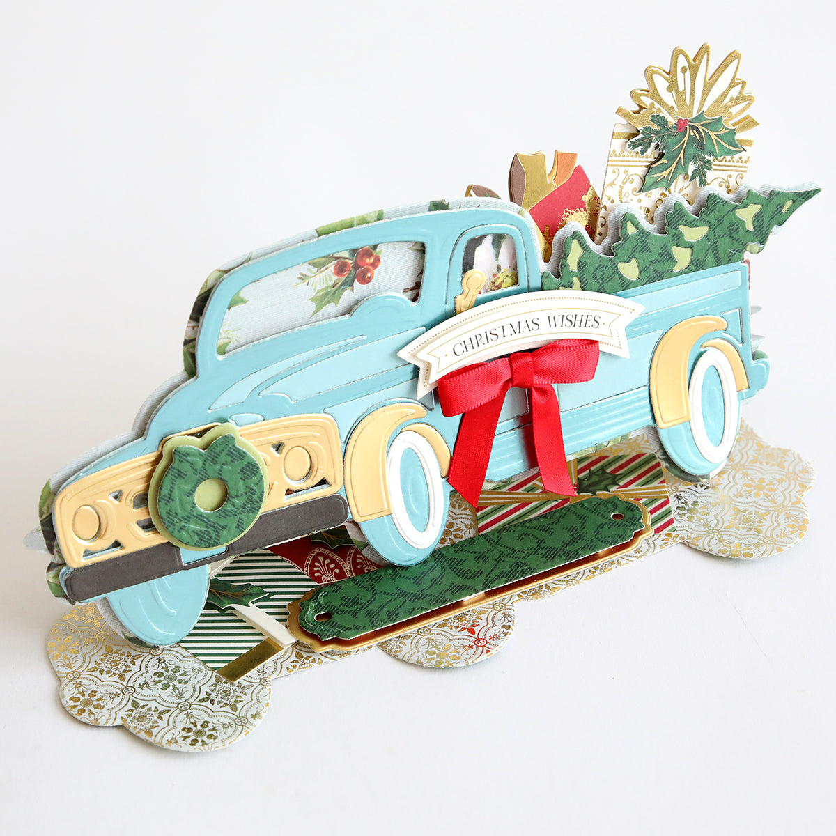 An Anna Griffin vintage themed Christmas card featuring the Christmas Truck Easel Die, which includes a blue truck and a Christmas tree.