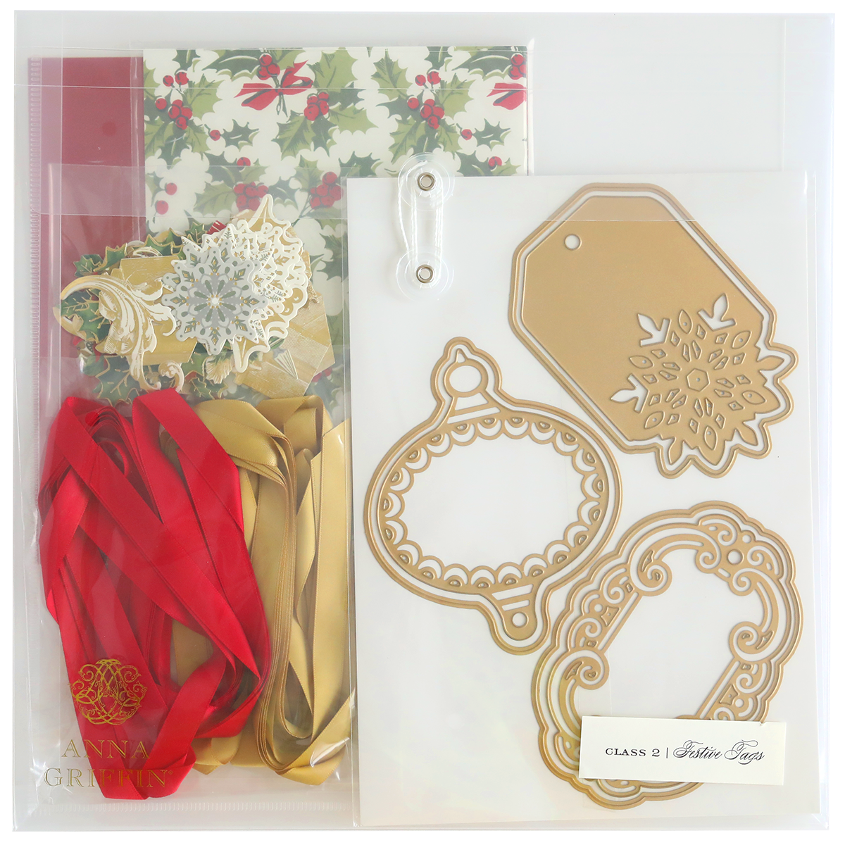 Festive Tags Dies and Materials kit includes holly-themed cardstock, satin red and gold ribbons, decorative cutout designs, and festive metallic tags.