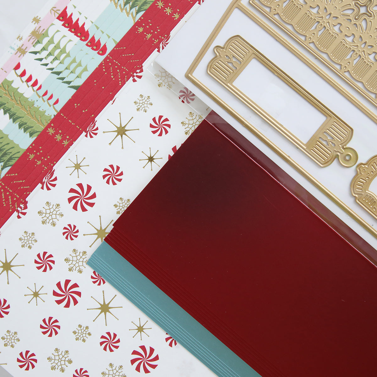 The Treat Boxes Dies and Materials collection features festive craft paper in red, green, and white adorned with holiday patterns like candy canes and stars, paired with decorative golden frames. It's perfect for crafting treat boxes or enhancing projects with 3D embellishments using luxury matte foil cardstock.