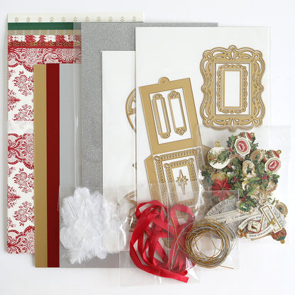 The Origami Ornaments Dies and Materials set is beautifully displayed on a flat surface, featuring patterned papers, cardstock, decorative cutouts, ribbons, white feathers, gold foil frames, 3D embellishments, and gold string.
