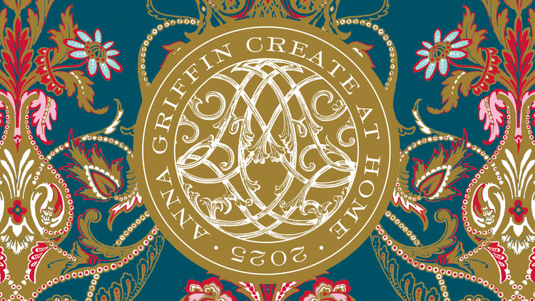 A gold circular emblem with ornate designs and the text “Anna Griffin Create at Home 2023” on a colorful floral patterned background.