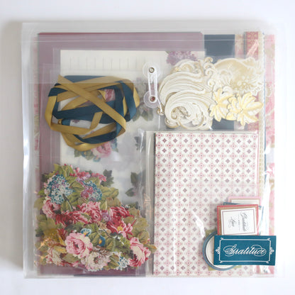 Anna Griffin | Create 2025: A clear folder filled with patterned papers, floral cutouts, decorative cards, ribbons, and ornate die-cuts—ideal for your next papercrafting event.