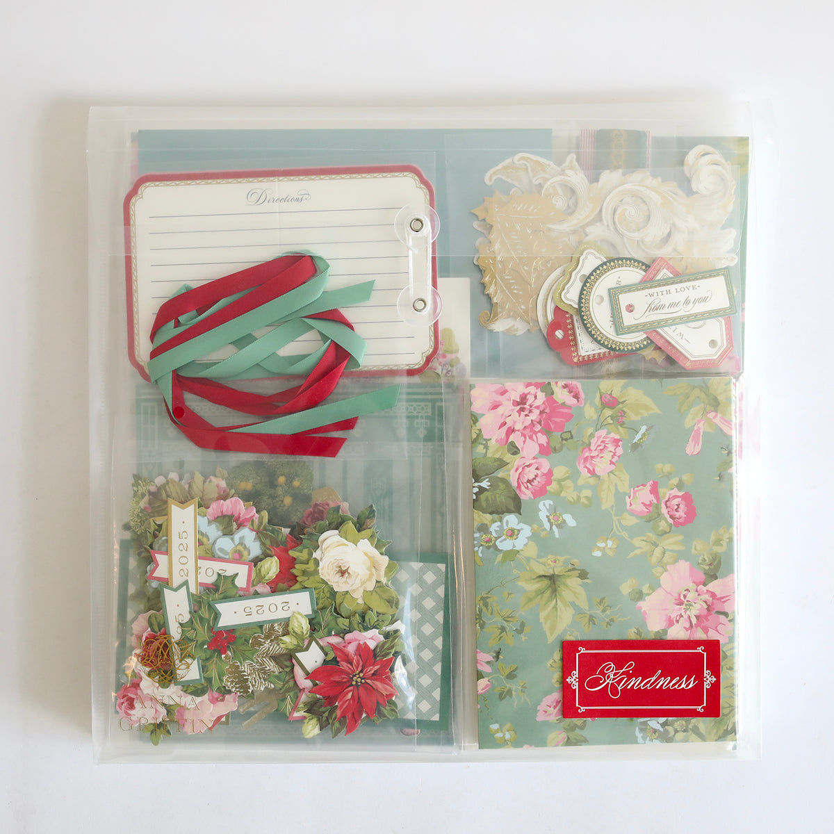 Anna Griffin | Create 2025 is a clear organizer with floral paper, ribbon, tags, note cards, and "Kindness" labels—perfect for papercrafting events or inspiring new crafting techniques.