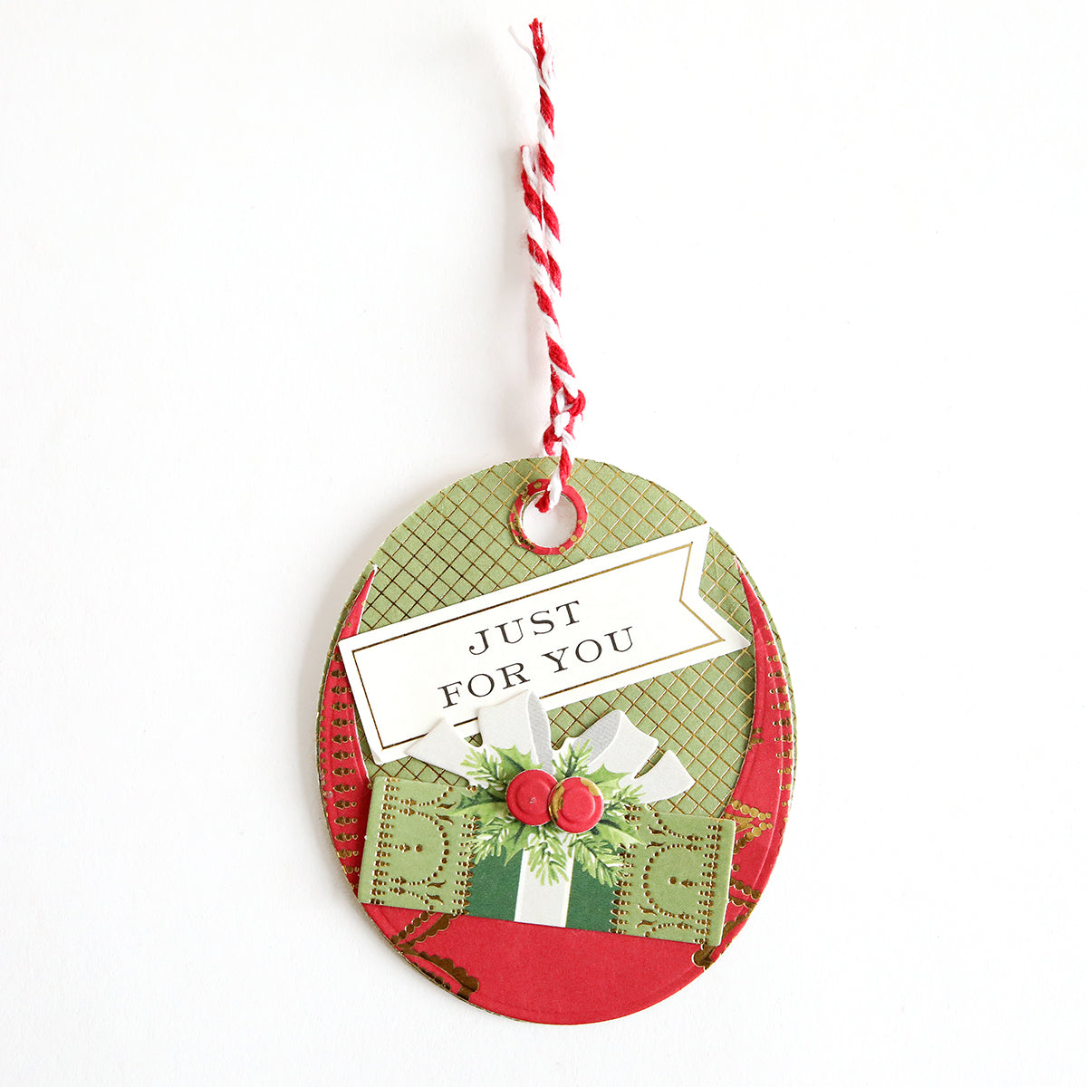 The Creative Tag Dies create oval gift tags with red and white string, featuring a green present with a bow and "JUST FOR YOU"—ideal for handmade tags or for adding a festive touch to your Advent Calendar.