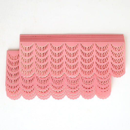 Pink, intricately cut paper strips are layered in a neat, overlapping pattern against a white background, similar to the Coral Scallop Diecut Wrap 10 pack often used for custom wedding invitations.