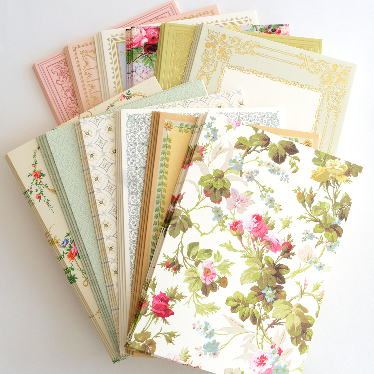 Delightful Collage Toppers and Cards features vintage-style patterned cards with floral designs and ornate borders, fanned out on a white background—ideal for your next cardmaking bundle or as card toppers.