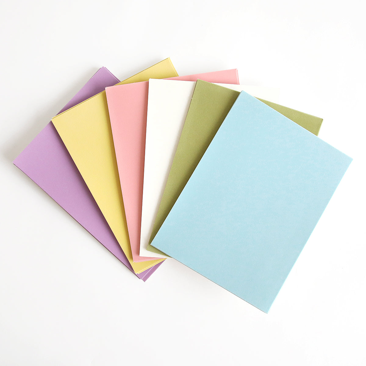 A stack of Easter Flocked Cardstock sheets fans out on a white background, featuring a delightful pastel palette of purple, yellow, pink, white, green, and blue—ideal for Easter crafts or adding vibrant color to any project.