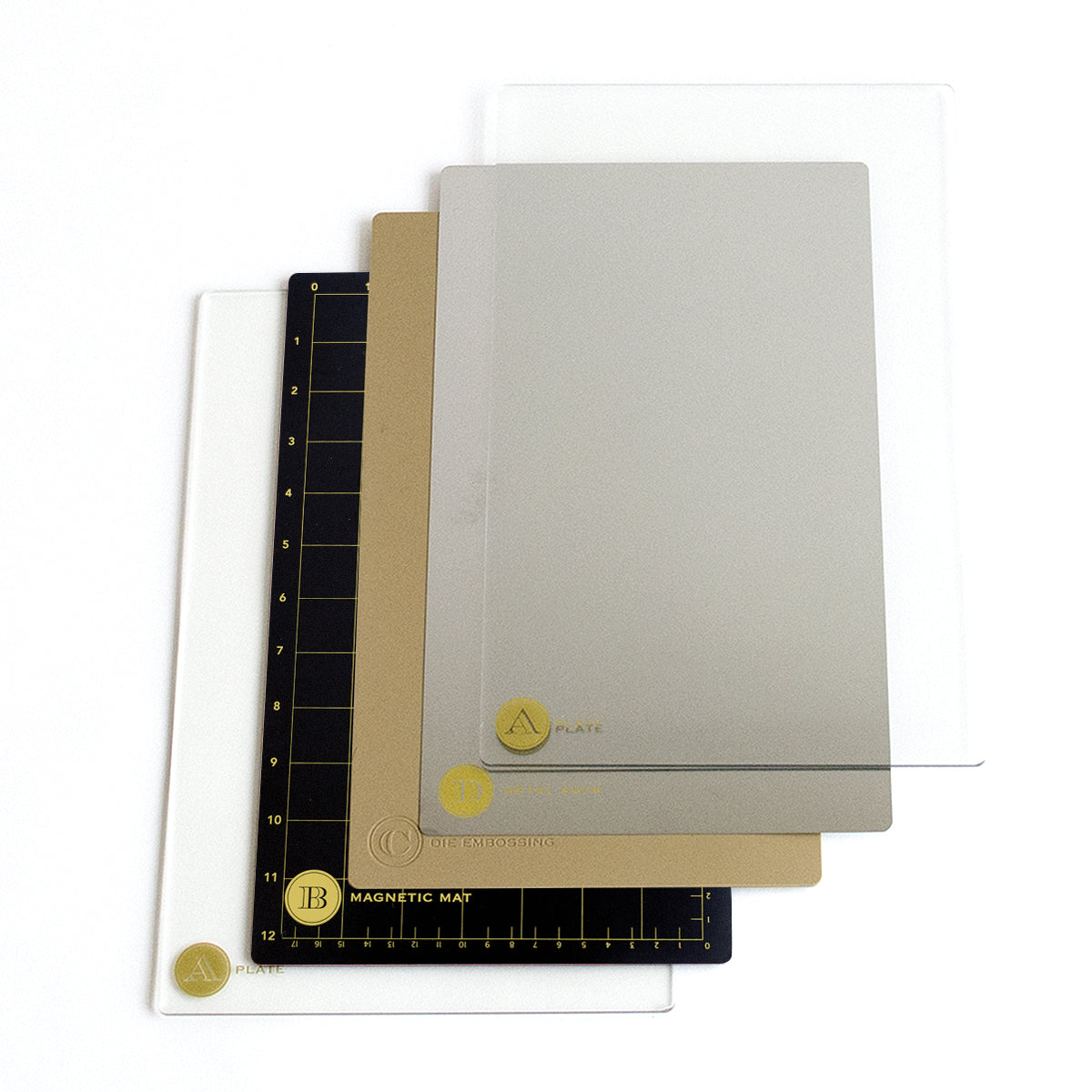 A stack of Empress Large Full Plate Set including a magnetic mat, an embossing mat, and clear plastic sheets on a white background.