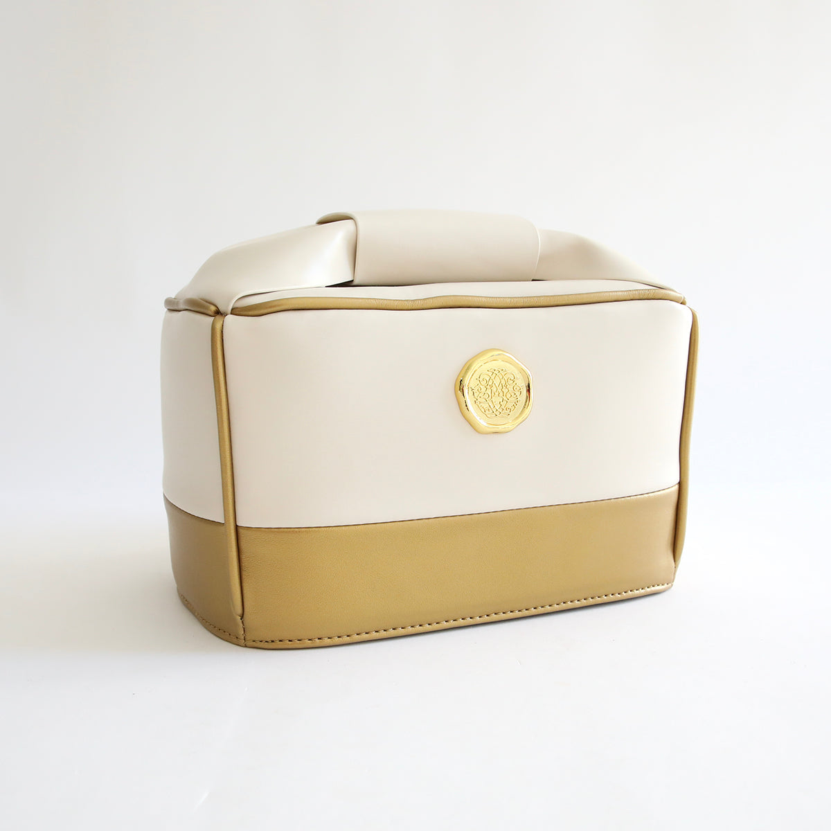 A white Empress Mini Tote and Dust Cover cosmetic bag on a white surface.