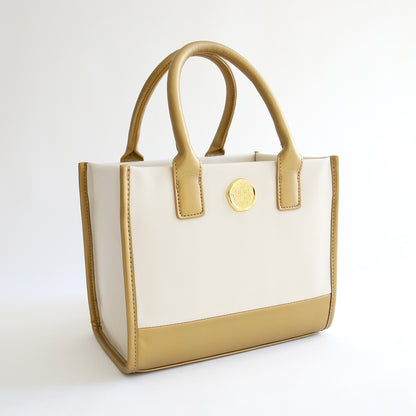 A white Empress Mini Tote and Dust Cover with a gold accent on a white background.