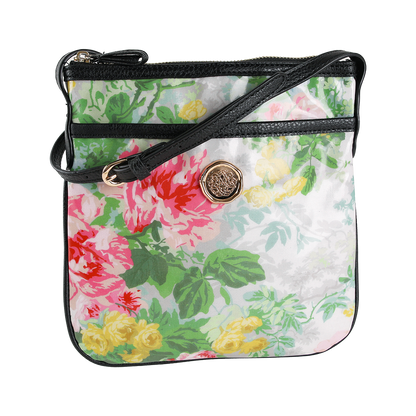 The Virginia Crossbody is a small purse crafted from laminated cotton, showcasing a charming floral print with black trim, a gold button detail, and a black adjustable strap. Perfect as a gift for women, this crossbody bag is displayed against a white background.