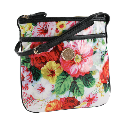 The Annalise Crossbody Bag is displayed against a white background, featuring a floral design with a gold emblem, black edging, and a coordinating black strap. Crafted from laminated cotton, this chic shoulder bag for women seamlessly combines elegance and practicality.