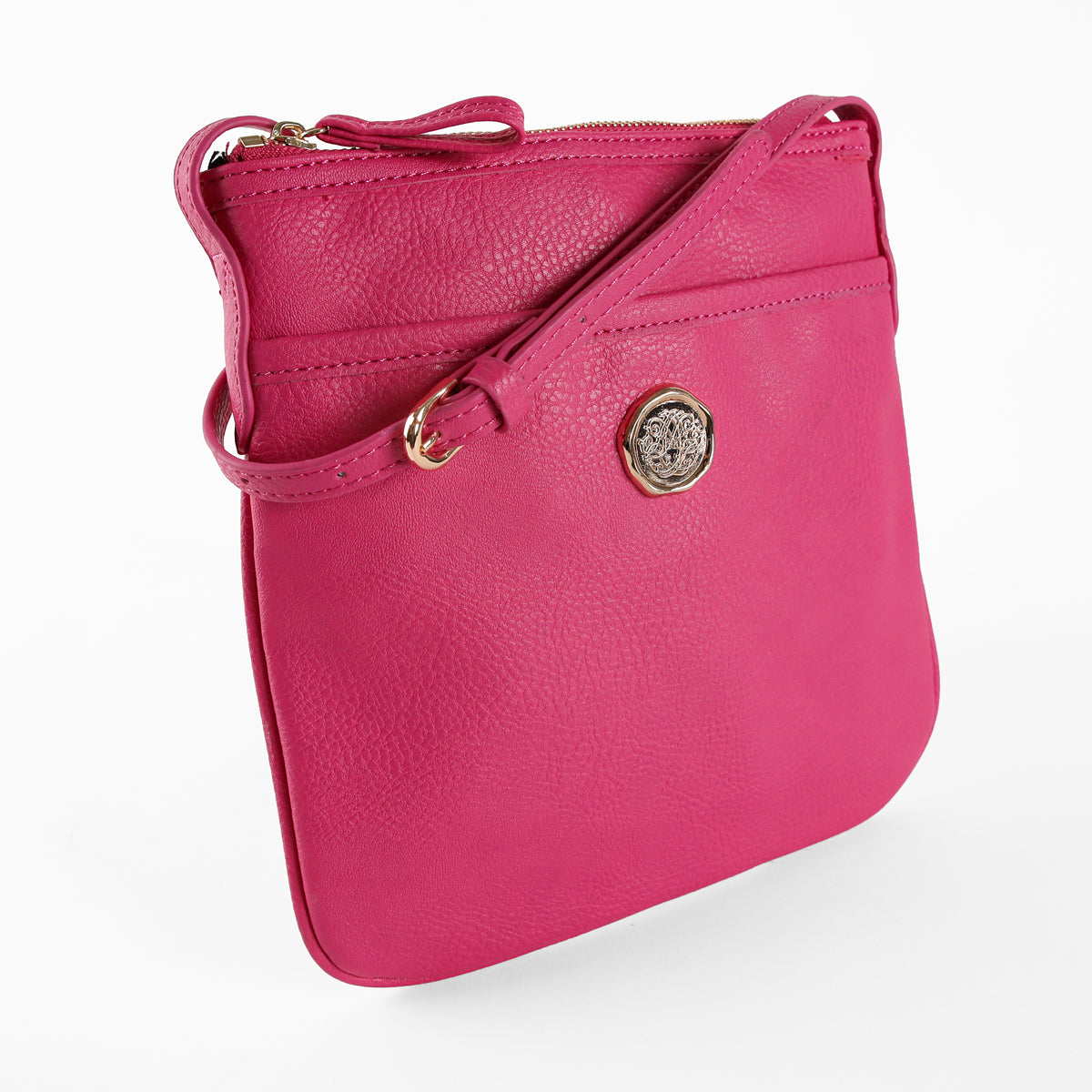The Raspberry Pink Crossbody Bag showcases vibrant faux leather with a gold emblem and zipper closure, set against a plain white background.