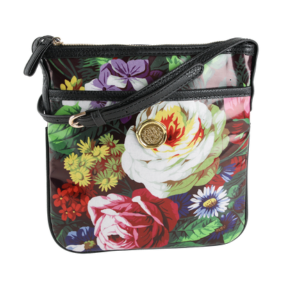 Introducing the Astrid Crossbody—a laminated cotton purse showcasing a vibrant floral print, black trim, gold medallion accent, and secure zip closure. This stylish hands-free crossbody bag is perfect for everyday wear.