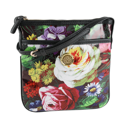 Introducing the Astrid Crossbody—a laminated cotton purse showcasing a vibrant floral print, black trim, gold medallion accent, and secure zip closure. This stylish hands-free crossbody bag is perfect for everyday wear.
