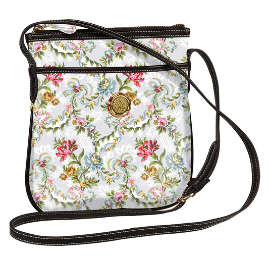 Phoebe Crossbody bags with floral pattern and brown leather trims, featuring a front logo medallion and adjustable strap.