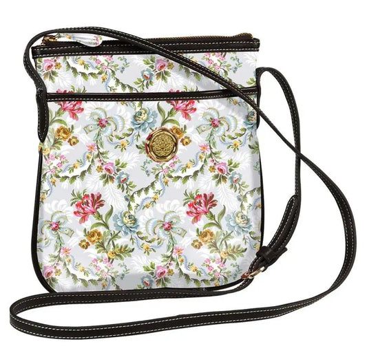 Crossbody bag with a floral pattern in pink, blue, and green tones, gold emblem in the center, and a dark adjustable strap.