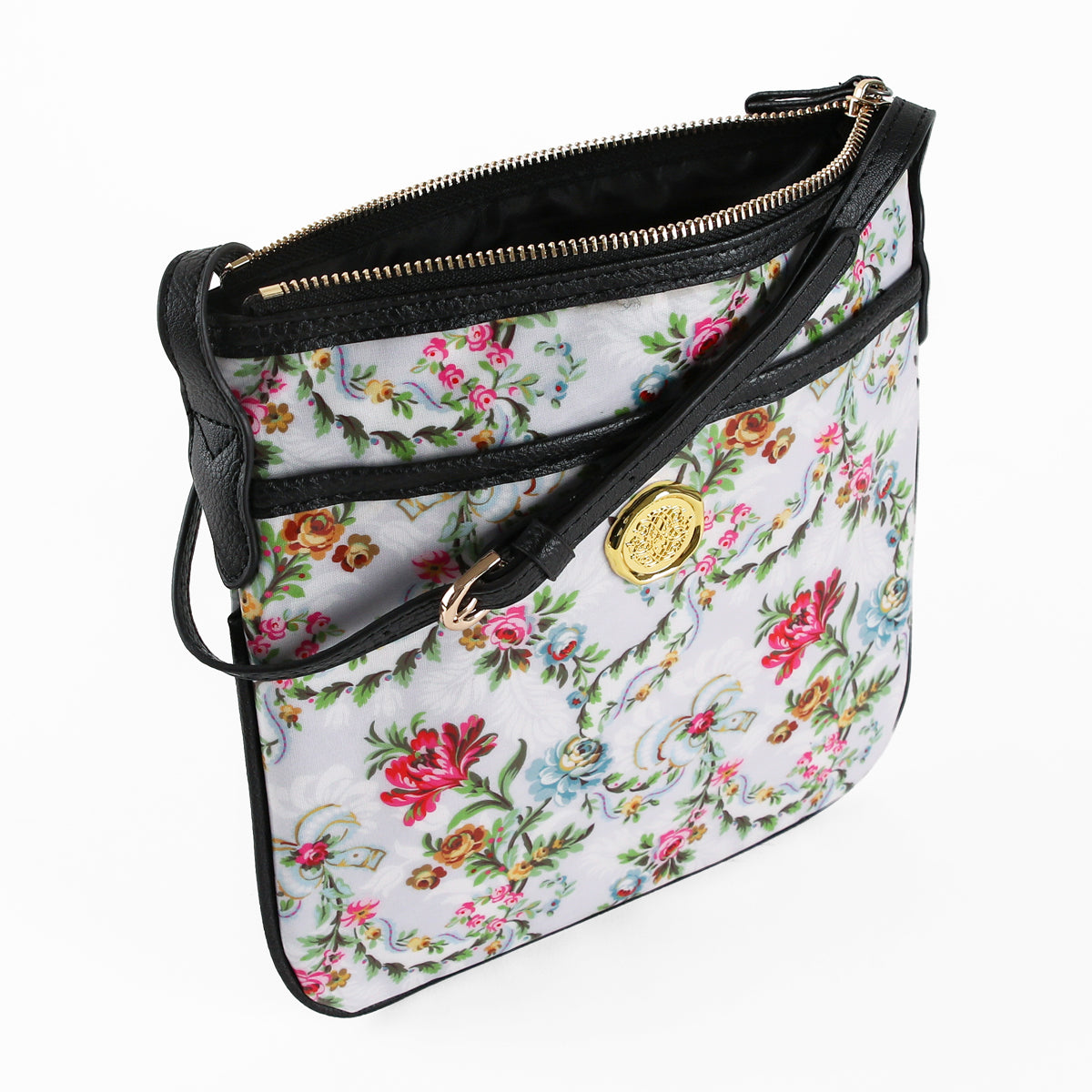 The Phoebe Crossbody is a stylish floral-patterned shoulder bag featuring a gold emblem, black leather trim, and a zippered main compartment. Crafted from laminated cotton, this versatile purse is showcased on a white background and makes an ideal gift for women who value both fashion and practicality.