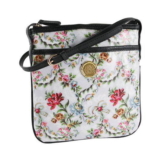 The Phoebe Crossbody is a small laminated cotton purse featuring a vibrant floral pattern with red, pink, and blue flowers on a white background. It comes with a black strap and gold medallion detail, making it both stylish and practical—a perfect gift for women.